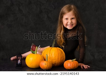 A girl with candies and pumpkins. Halloween concept
