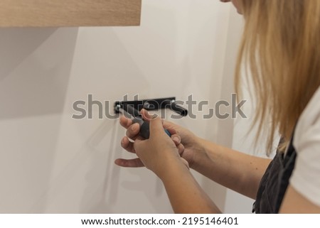 the girl spins the shelf for books on the wall. the girl is turned back to the camera close-up, blond hair and a black bandana on her head