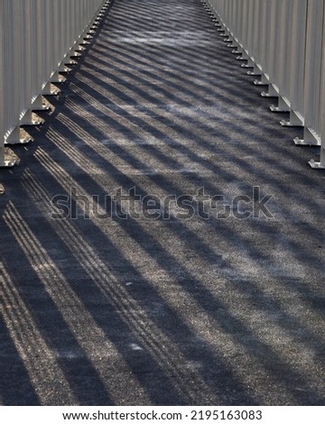 Railing shadow on the bridge. Bridge railing casts a shadow. Abstract bridge railing shadow. in the evening during sunset Royalty-Free Stock Photo #2195163083