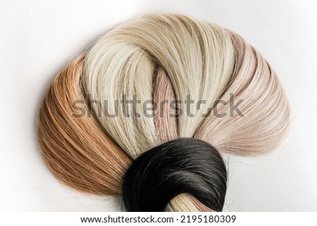 Curved hair samples for extension rolled up,different colors.White background.