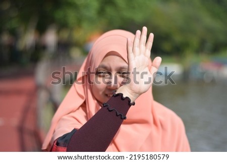 Selective Focus of A Shy Muslim Woman Wearing Peach Coloured Hijab With Blurred Background