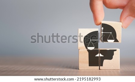 Ethics inside human mind, Business ethics concept. Hand hold ethics inside a head symbols in wooden cubes on dark background with copy space.