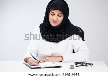 Arab female doctor noting in her office