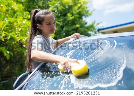 Women washing cars at home on vacation. Royalty-Free Stock Photo #2195201231