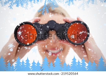Composite image of woman looking through binoculars against frost and fir trees in blue