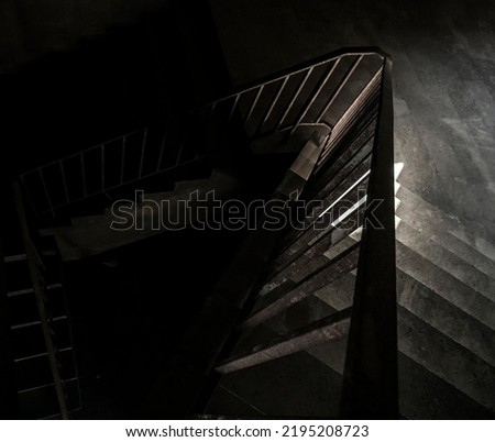 New concrete stairs in office building. rusty iron railing. indoor gray stairs with metal railing. light and shadow. Handrail shadow on the stone staircase. sunny day