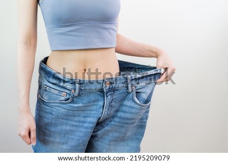 Shape slender, thin waist, attractive slim asian young woman, hand show shape her weight loss, wearing in big, large or oversize jeans, excess lose by diet and exercise. People body fit healthy. Royalty-Free Stock Photo #2195209079