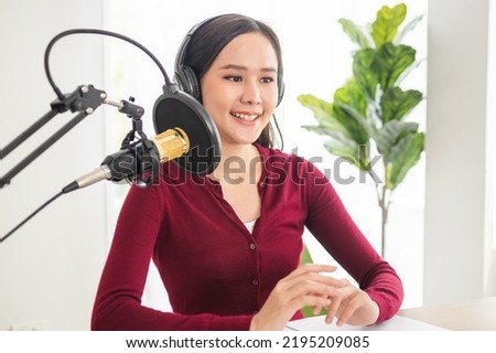 Beautiful asian young woman radio host working in headphones, microphone while talk, conversation and recording podcast, live on social media.Technology of on-air online in broadcasting at studio.