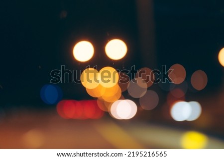 abstract blurry shiny bokeh background of street or road traffic night light in the city, view from a car in a dark scene, transportation concept in town urban highway motion for travel