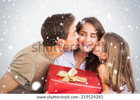 Composite image of Father and his daughter offering a red gift against snow falling