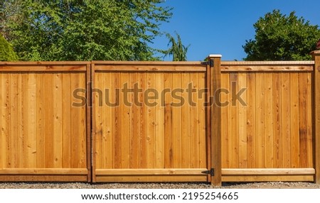 Nice new wooden fence around house. Wooden fence with lawn. Street photo, nobody, selective focus Royalty-Free Stock Photo #2195254665