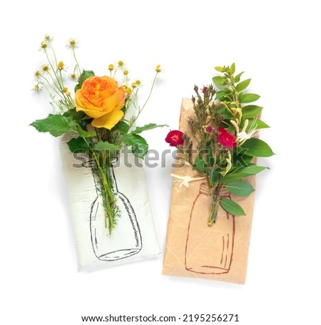Wrapping paper gift with bouquet of yellow and crimson roses, delicate daisies and painted vase  on white background. Creative holiday present. 
Flat lay, top view concept with copy space.