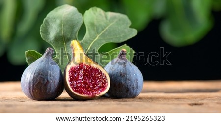 Ripe fig fruits with leaf close-up. Beautiful sweet fresh organic figs on a wooden table. Label design. Healthy vegan food Royalty-Free Stock Photo #2195265323