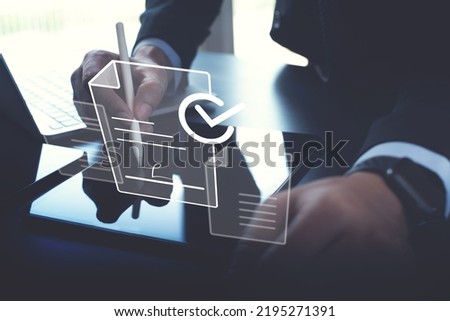 E-signing, electronic signature, document management concept. Businessman using stylus pen signing to approve digital document on digital tablet via mobile app, paperless office