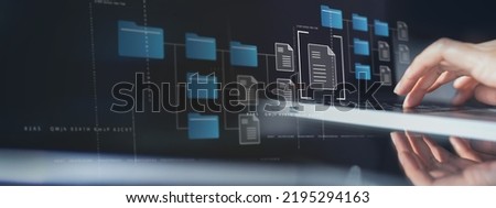 Document Management System (DMS) being setup by IT consultant working on laptop computer in office with document directory. Software for archiving, searching and managing corporate file information Royalty-Free Stock Photo #2195294163