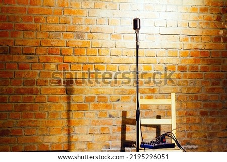 Microphone ready on stage against a brick wall ready for the Karaoke performer