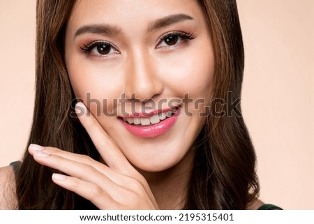Closeup portrait of ardent young girl with healthy clear skin and soft makeup looking at camera and posing beauty gesture. Cosmetology and beauty concept.