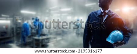 engineer standing in factory. Wide image for banners, advertisements. Royalty-Free Stock Photo #2195316177