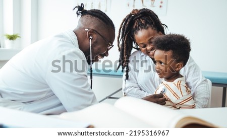 Smiling male doctor listen consult cute african boy make notes in patient card at medical checkup appointment, black mother and child son visit pediatrician talk in clinic, children healthcare concept
