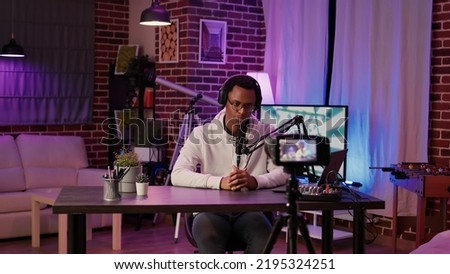 Selective focus on digital video camera screen recording african american influencer hosting podcast for vlog post. Content creator filming and streaming live internet show from home studio.