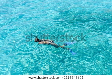 Girl snorkelling as she swims in clear tropical water during a vacation