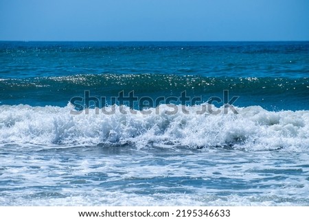 Ocean waves crashing on sandy beach. Sea waves breaking on shore. Nature splash on summer day. Sea wave crashing on beach. Summer holidays concept. Splashing sea water with foam.
