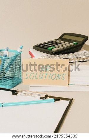 Text showing inspiration Hr Solutions. Conceptual photo Outsourced Human resources consultancy and support Experts Important Idea Shown On Phone On Desk With Cup With Pencils And Books.