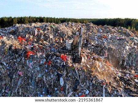 Landfill with Construction waste and Demolition waste (CDW). Trash disposal for recycling and re-use. Excavator working on industrial landfill. Recycling of building waste materials. Secondary raw. Royalty-Free Stock Photo #2195361867