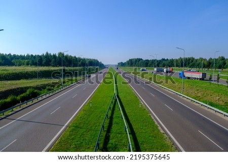 Expressway in several lanes S2 in Poland and a stop with several trucks. Summer August