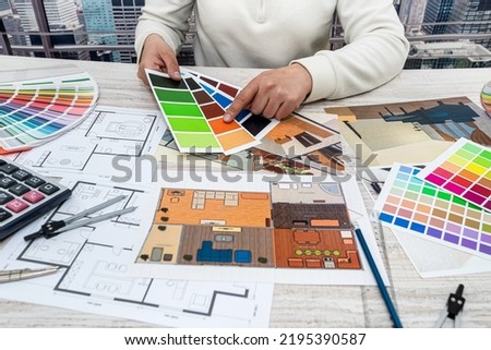 top view men's hands choose the colors of the design for the drawings of a particular architecture. Pallet selection concept
