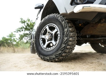 SUV wheel close up is on nature background in summer. off-road car tyre close up outdoor. mud tire close up is on off road car.  Royalty-Free Stock Photo #2195395601