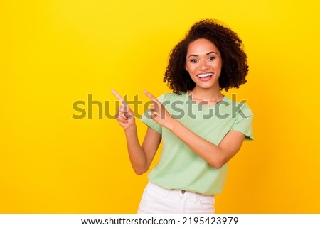 Photo of sweet brunette curly lady indicate promo wear t-shirt isolated on bright yellow color background