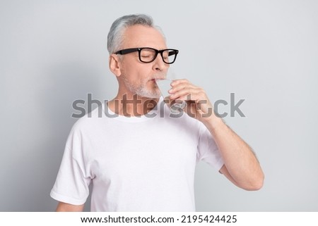 Photo of aged person closed eyes hold drink fresh water isolated on grey color background