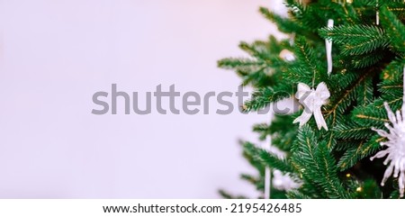 Banner with green Christmas tree with silver toys on white background with copy space. High quality photo