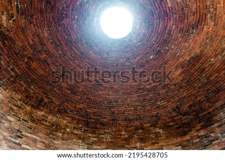 Light comes through a hole in a brick building pottery house.