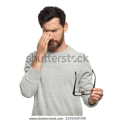 Man suffering from eyestrain on white background Royalty-Free Stock Photo #2195439709