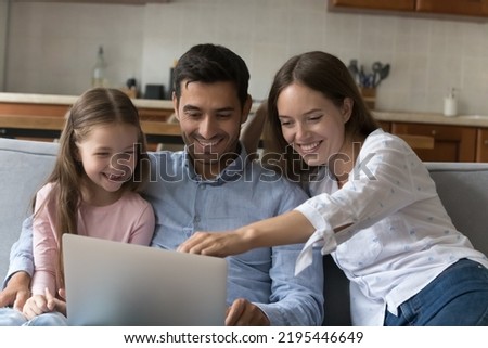 Couple and daughter spend weekend at home using laptop, family make order buying remote e-services, choose goods on-line, enjoy easy e-commerce services for comfort life. Modern technologies concept Royalty-Free Stock Photo #2195446649