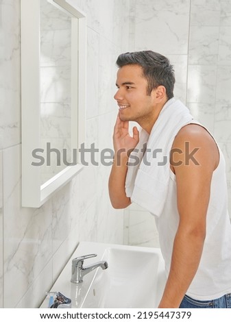 Man who wants to shave in front of the mirror, athlete and towel style, beard in the bathroom. Uzbekistan people. Royalty-Free Stock Photo #2195447379