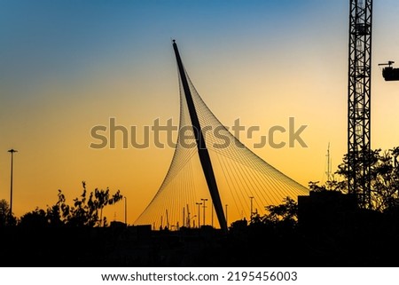 The Chords Bridge - light rail and pedestrian bridge at the entrance to Jerusalem. Bridge silhouette in sunset light. Royalty-Free Stock Photo #2195456003