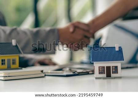 business people shaking hands in the office Sign a home purchase contract between the buyer and the seller. Real estate agent after signing documents and house plans on wooden table