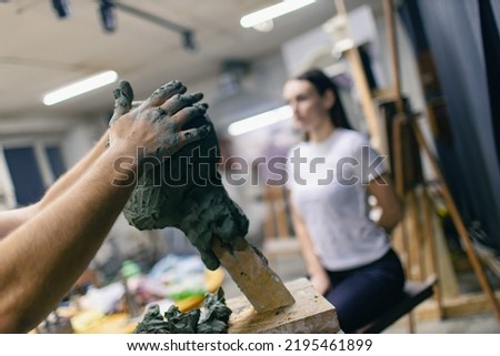 Man sculptor creates sculpt bust clay human woman model sculpture. Statue craft creation workshop studio. Royalty-Free Stock Photo #2195461899