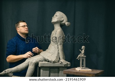 Man sculptor creates sculpt bust clay human woman sculpture. Statue craft creation workshop. Small business. Royalty-Free Stock Photo #2195461909