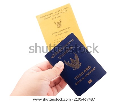 Hand holding Thailand official passport and vaccine passport are on isolated white background with a clipping path.