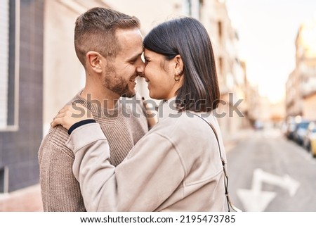 Man and woman couple smiling confident hugging each other standing at street