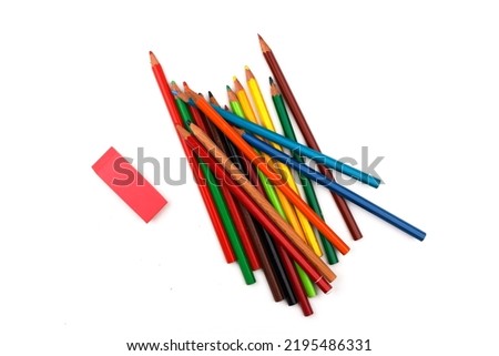 some used older wooden pencils are lying on a white surface together with a red eraser. Isolated on white background
