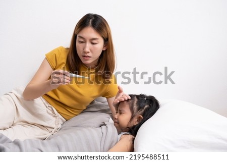 Selective focus at mother face. Young Asian girl who has fever. that taking care and touch to feel body temperature by her mother inside of the bedroom. Sick and illness of young children, mother care Royalty-Free Stock Photo #2195488511