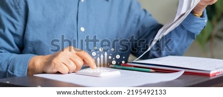 close up senior woman hand use calculator for counting about expenses monthly or spending money with virtual icon in living room for financial and economy lifestyle concept Royalty-Free Stock Photo #2195492133