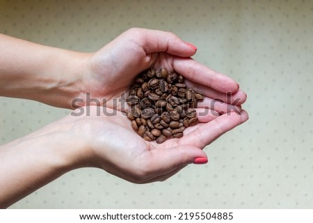 Hands are folded together and holding coffee beans. High quality photo