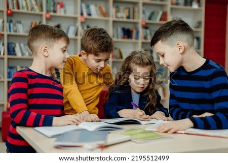 school children in the library reading books, doing homework, prepare a school project for lessons. High quality photo