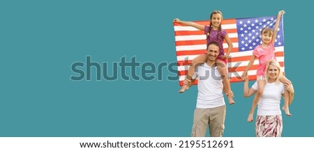 Happy young family with national flags of USA near blue wall